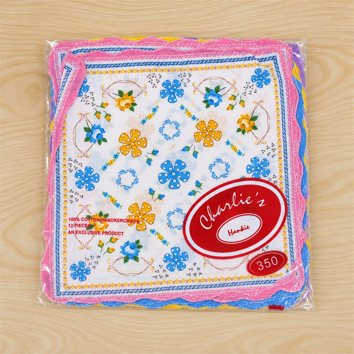 A clear plastic package contains multiple colorful floral handkerchiefs with scalloped edges, displaying a red brand label.