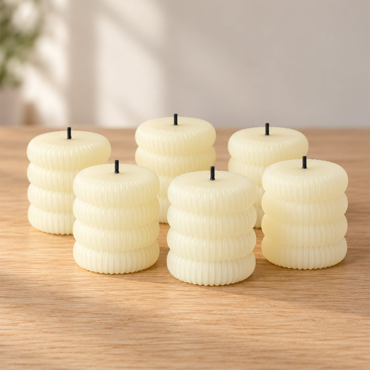 Six unlit ribbed flameless LED tealight candles arranged on a light wooden table surface.