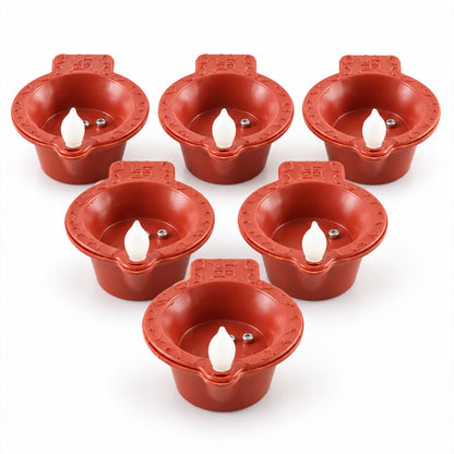 A top-down view of six red plastic diyas, each with a white LED flame and two silver sensor contacts, on a white surface.