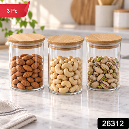 Three glass jars with bamboo lids, containing different nuts, on a kitchen counter with a green plant in the background.