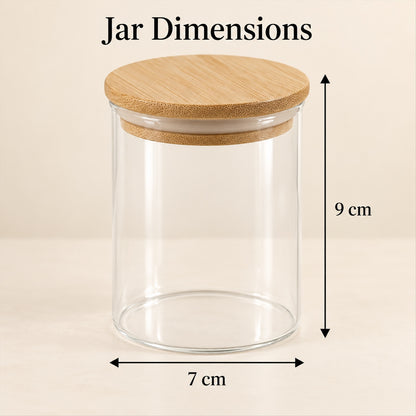 A single empty clear glass jar with a bamboo lid, showing its dimensions of 9 cm height and 7 cm width.