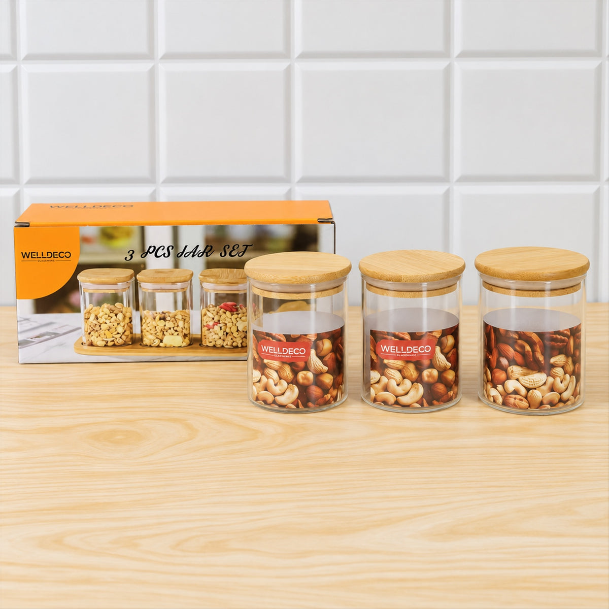 Three glass jars with bamboo lids, two filled with nuts, next to an orange box displaying
