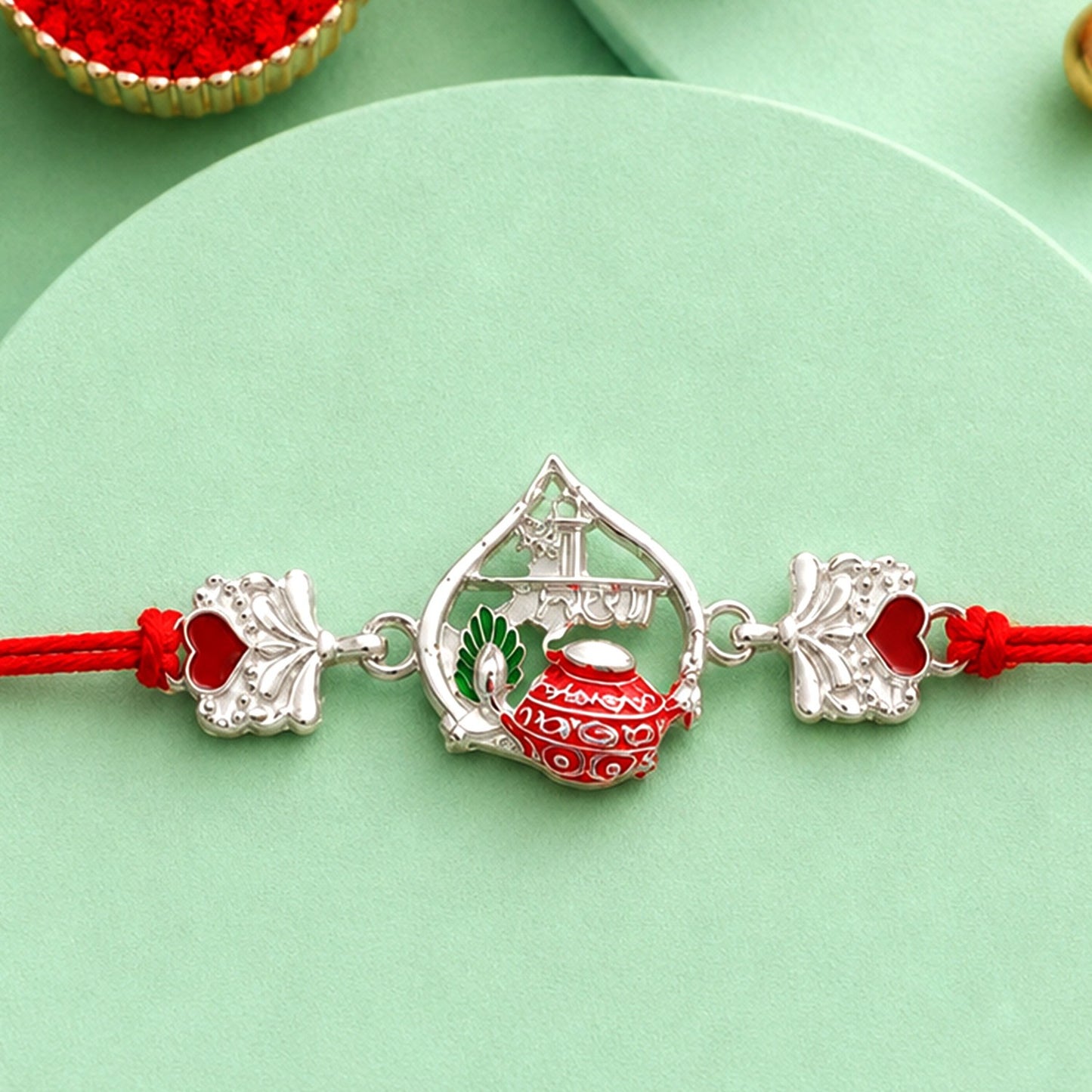 Silver Crown Rakhi with pink stone and red mauli thread for Raksha Bandhan celebration