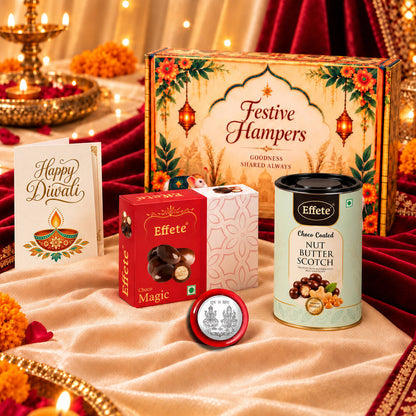 Festive hamper box, red chocolate box, nut butterscotch tin, silver coin, and greeting card on a decorative cloth.