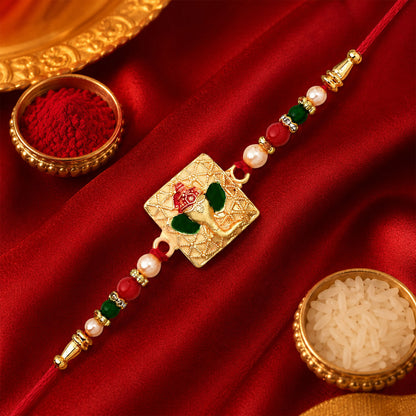 Side profile of the Golden Ganpati Rakhi tied with a traditional thread.