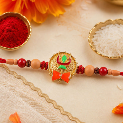 Trishul Damru Rakhi with peach beads and red thread, ready for Rakshabandhan