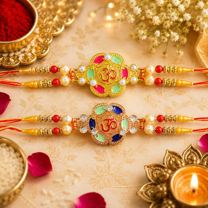 Two ornate gold and rose gold Om bracelets with colorful enamel, pearls, and beads on a patterned beige cloth with ritual