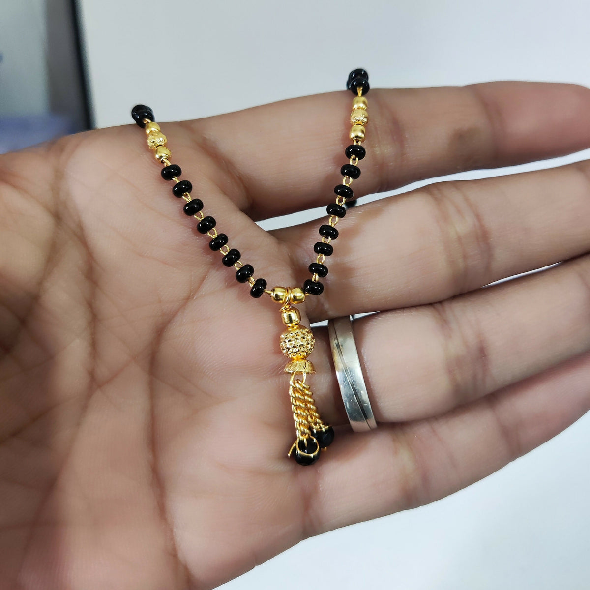 Woman showcasing black beaded mangalsutra jewellery