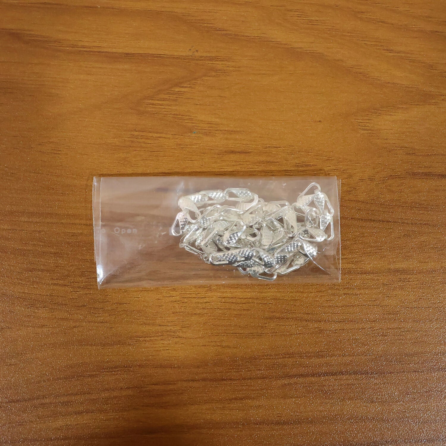Stylish silver tone textured chain necklace on white surface