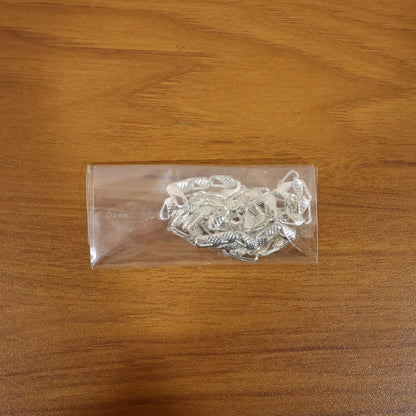 Stylish silver tone textured chain necklace on white surface