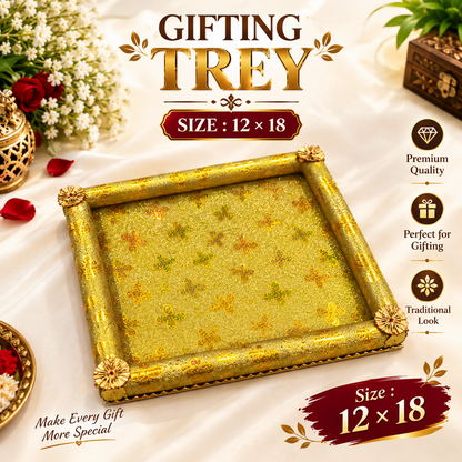 A golden rectangular tray with a glittery surface and ornate floral corner decorations sits on a white cloth.