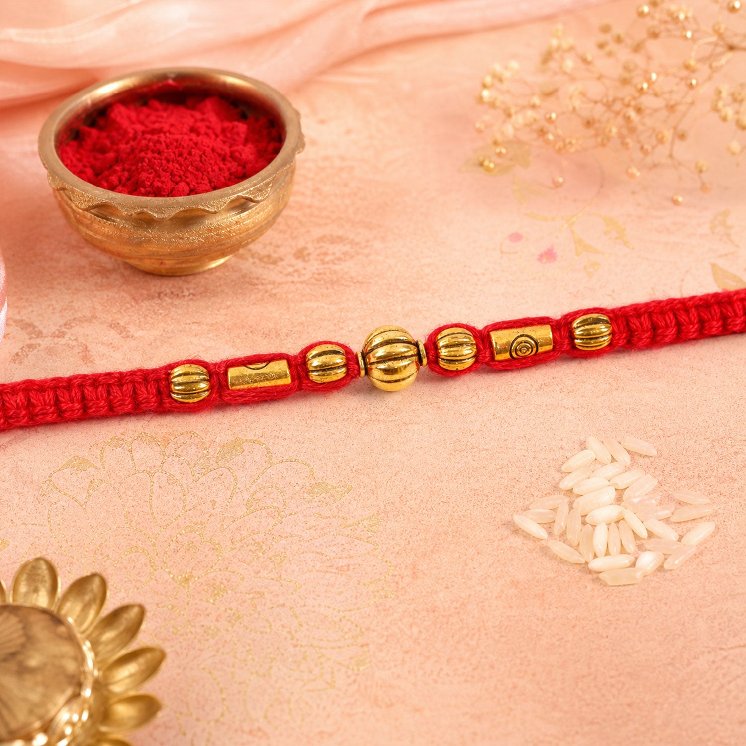 Red Braided Rakhi with a Row of Smooth Golden Bead Accents