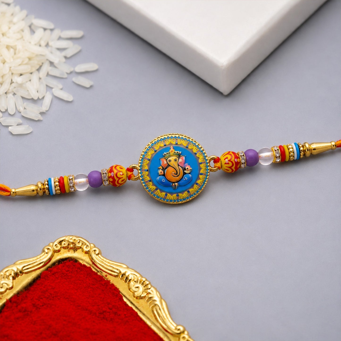 Lord Ganesha Rakhi with round coin centerpiece and decorative beads for Raksha Bandhan
