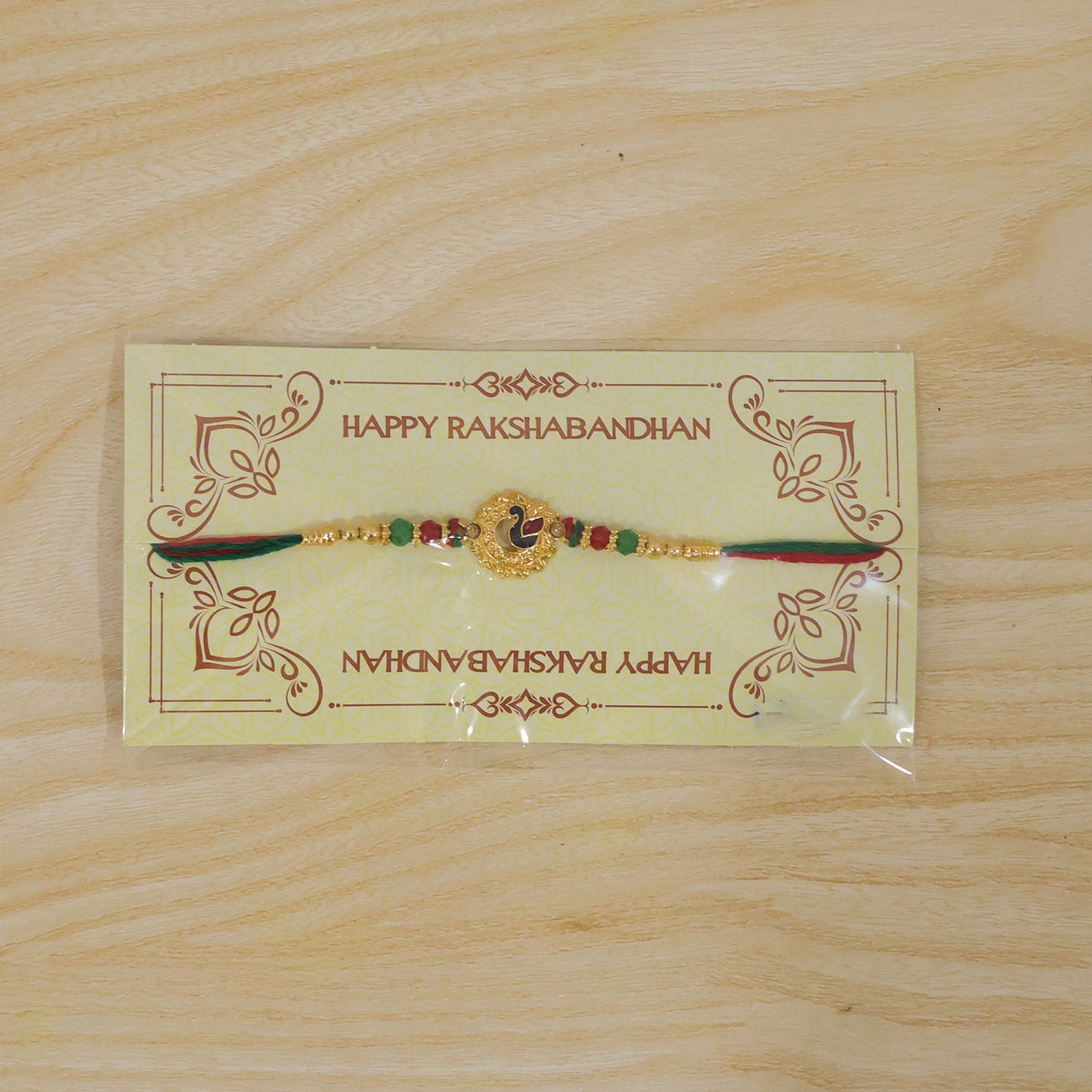 Peacock Floral Golden Rakhi with Blue Green Enamel, Red Beads and Decorative Centre