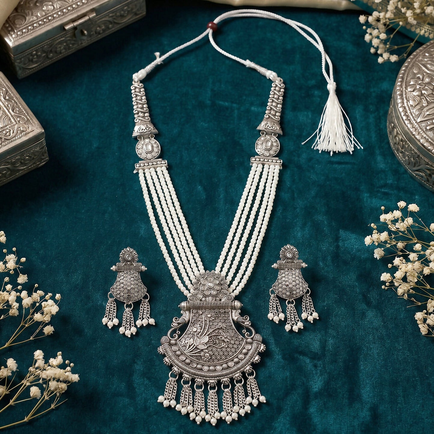 Side view of traditional silver necklace set with pendant and earrings