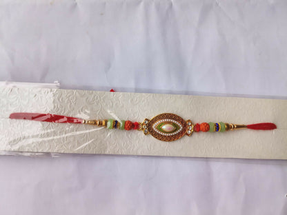 A decorative bracelet with a central oval stone and colorful beads is displayed on a textured white paper background.