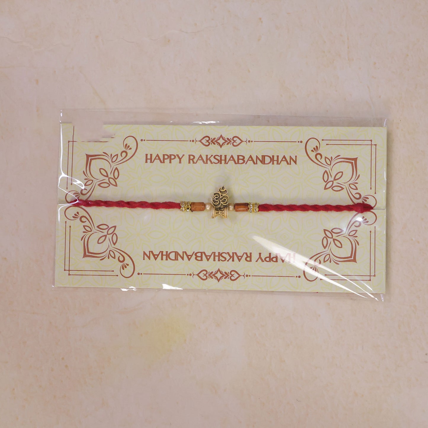 Red Braided Rakhi with Golden Om Pendant and Warm Amber Beads
