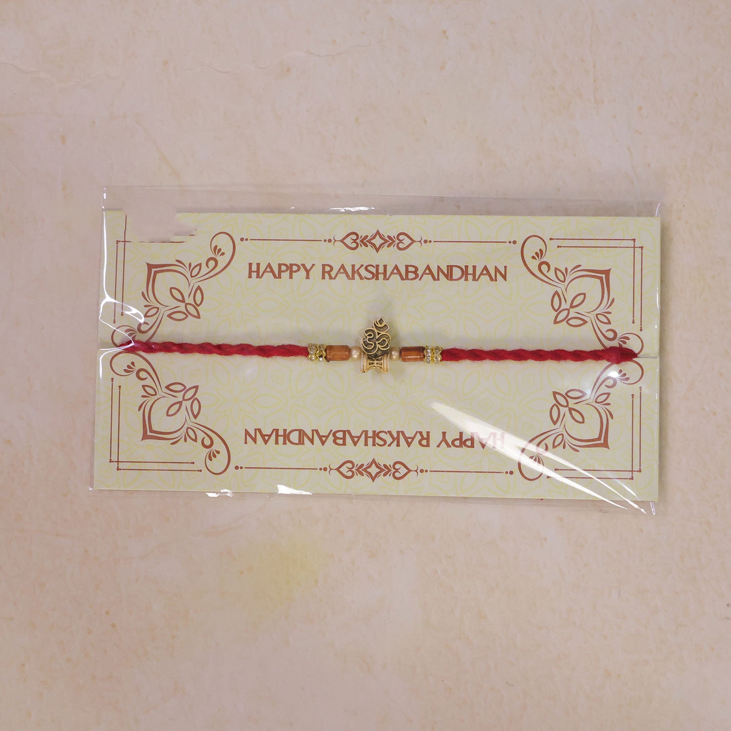 Red Braided Rakhi with Golden Om Pendant and Warm Amber Beads