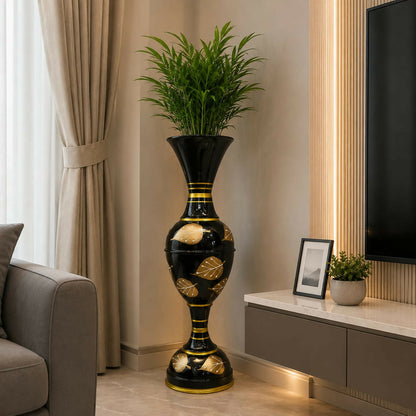Side view of tall metal vase with hand-painted gold leaf accents