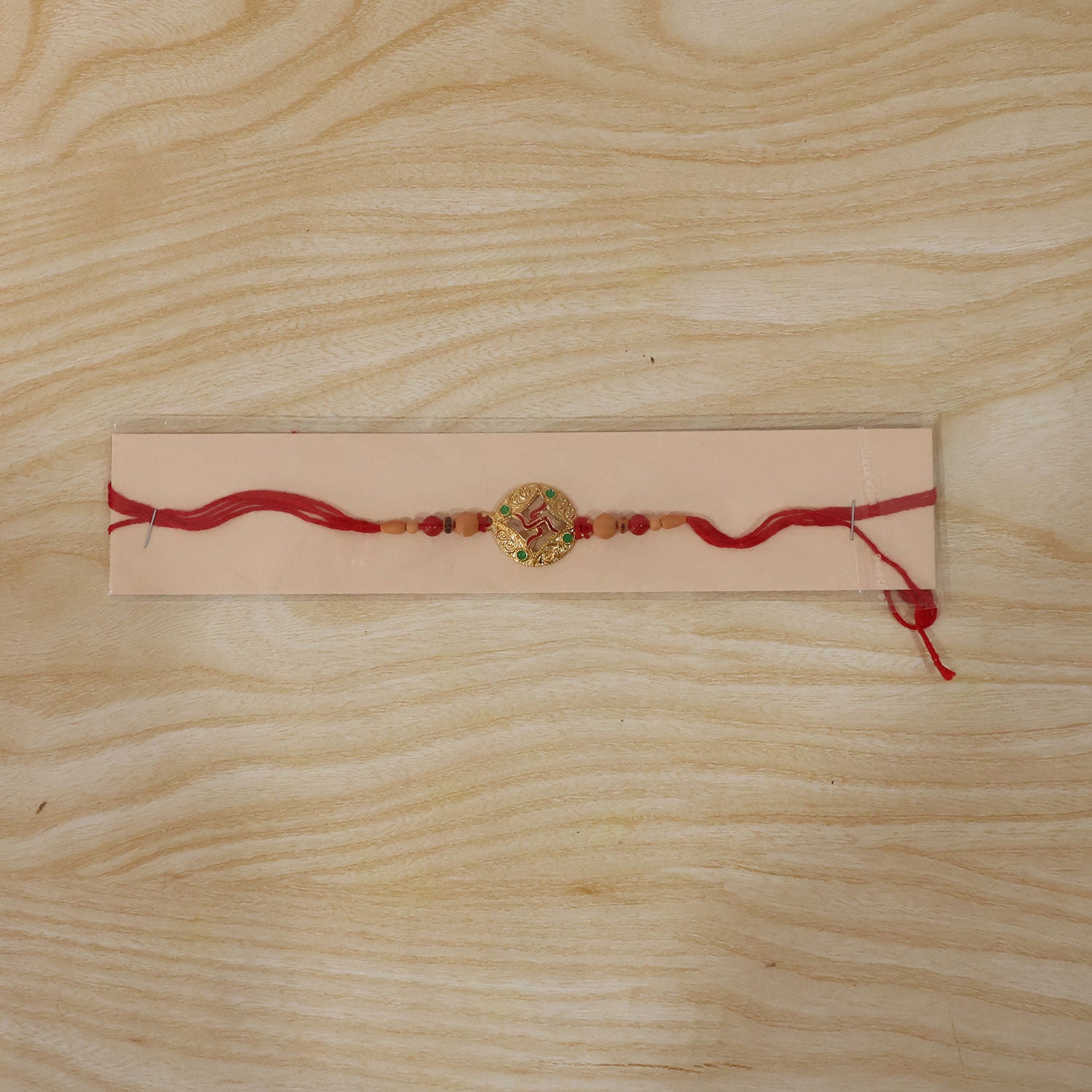 Multicolor Swastik Rakhi with Peach Beads and Navy Backdrop