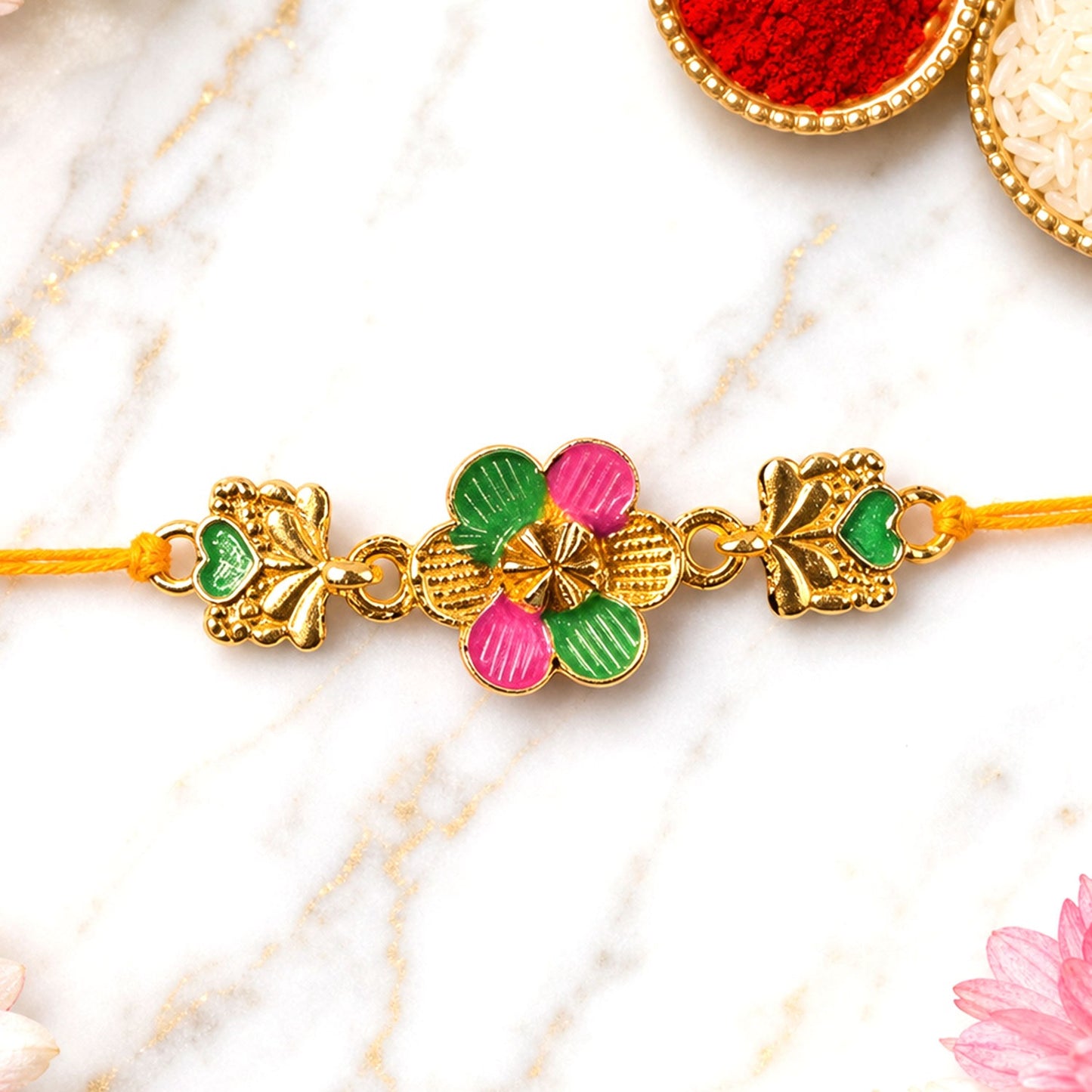 Golden Meenakari Rakhi with a prominent flower and leaf design, ideal for Rakshabandhan celebrations.