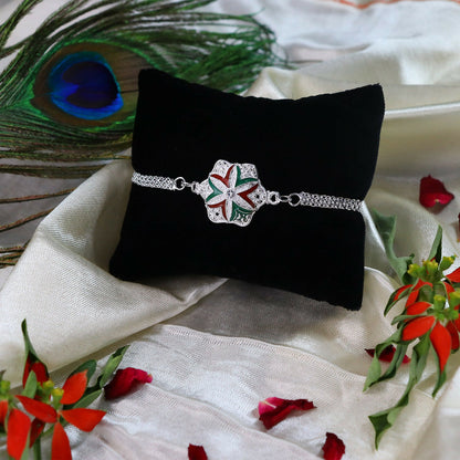Elegant flower rakhi with silver chain displayed on white background