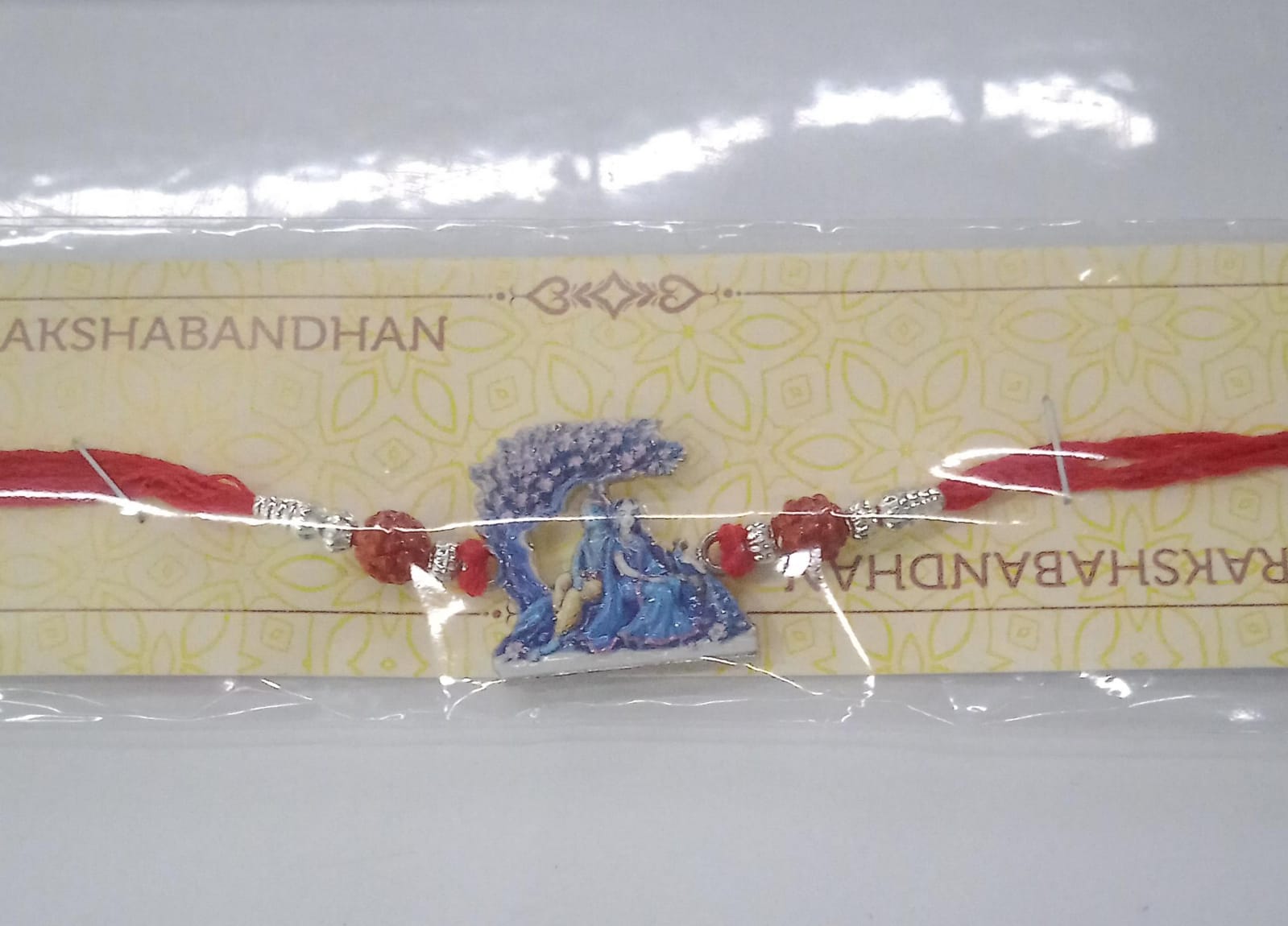 Radha Krishna Rakhi under Tree Design with Rudraksha & Red Mauli Thread