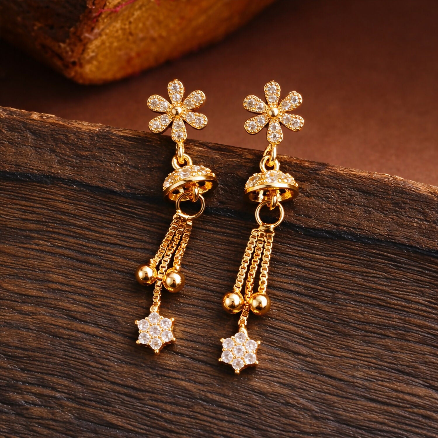 Rose gold drop earrings featuring sparkling starburst floral design