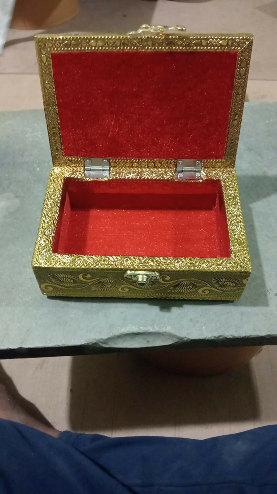 Open brass jewelry box showing interior storage space