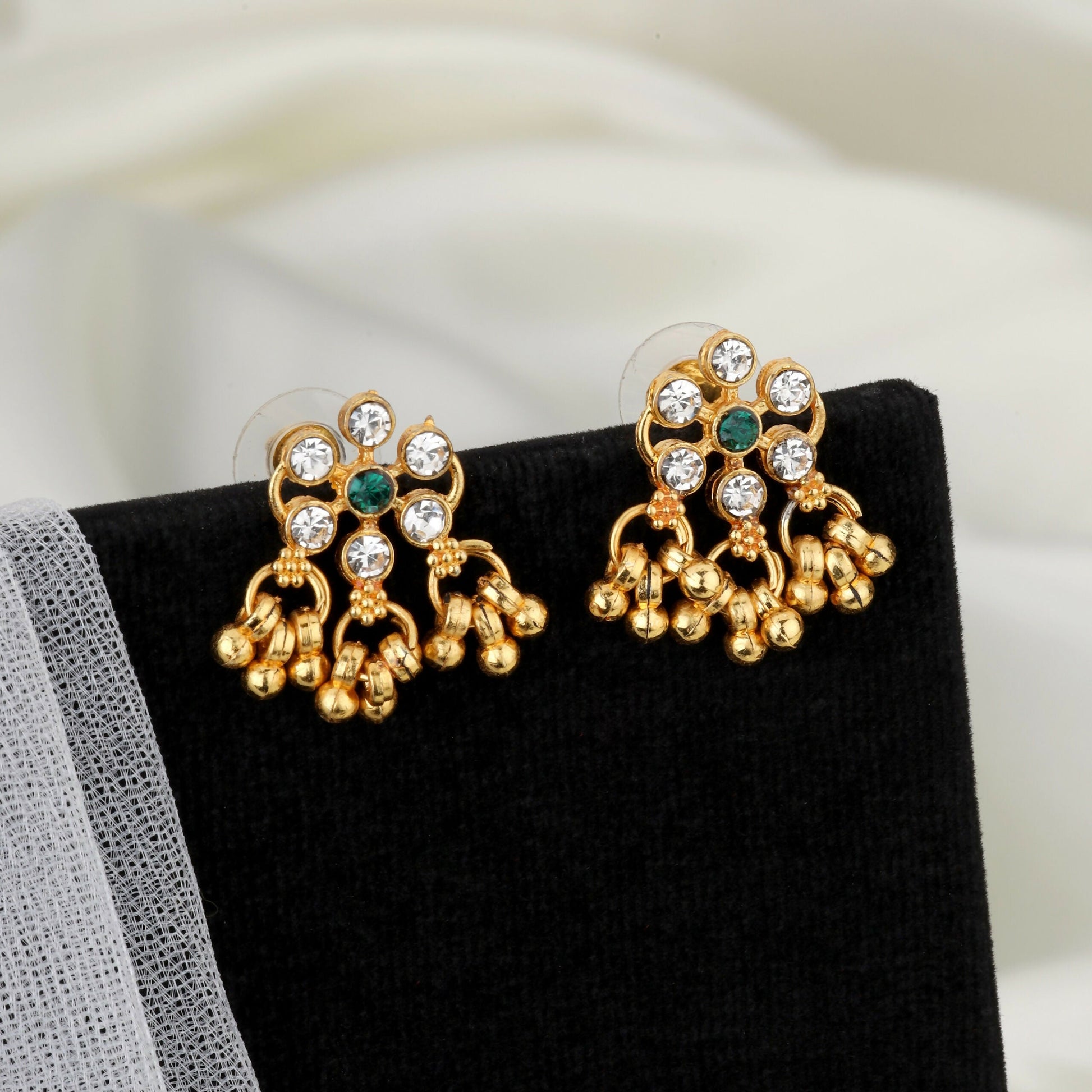 Close-up of gold lotus motifs with green enamel and pearl clusters