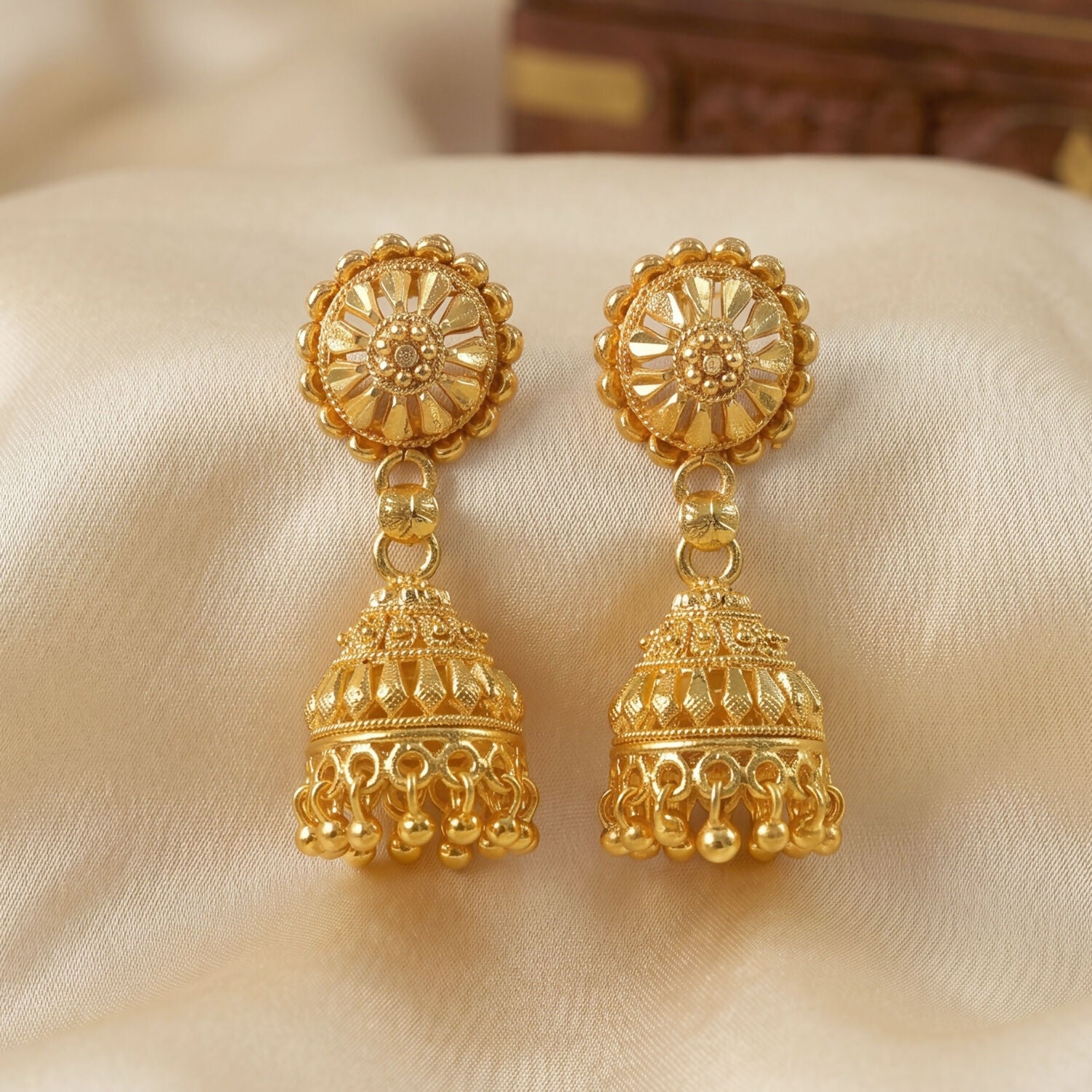 Gold jhumka earrings highlighting pearl accents
