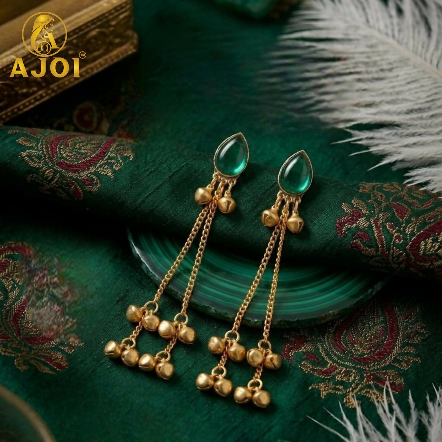 Detailed shot of a single green teardrop stone earring with ghungroo bells