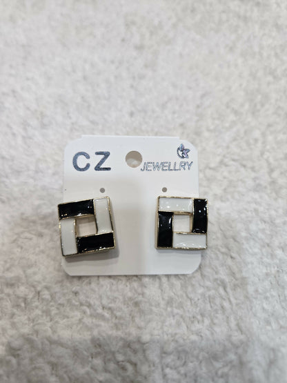 A pair of black and white square earrings displayed on a white jewelry card.