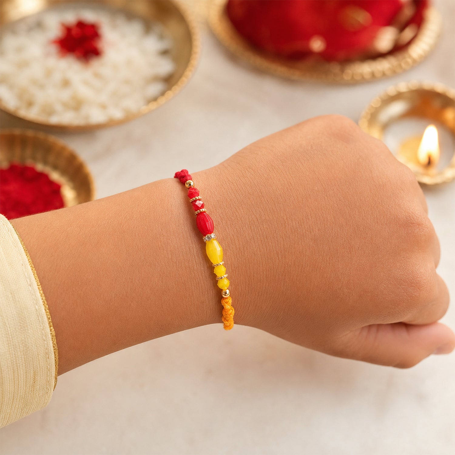 Red Thread Rakhi with Yellow and Orange Bead Pendant Accents