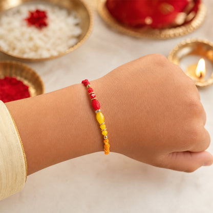 Red Thread Rakhi with Yellow and Orange Bead Pendant Accents