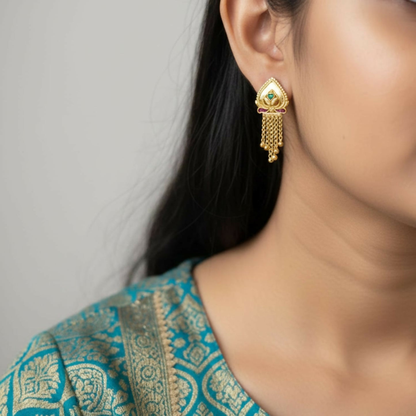 Close-up of traditional golden jhumka earrings featuring dangling golden beads