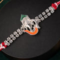 Traditional Rakhi showcasing Ganesha Charm, red stone accents and gift look for Gift