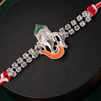 Traditional Rakhi showcasing Ganesha Charm, red stone accents and gift look for Gift
