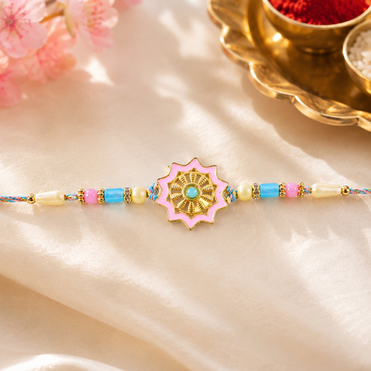 Pastel Floral Charm Rakhi with Pink Blue Beads and Elegant Festive Gift Styling Ideas
