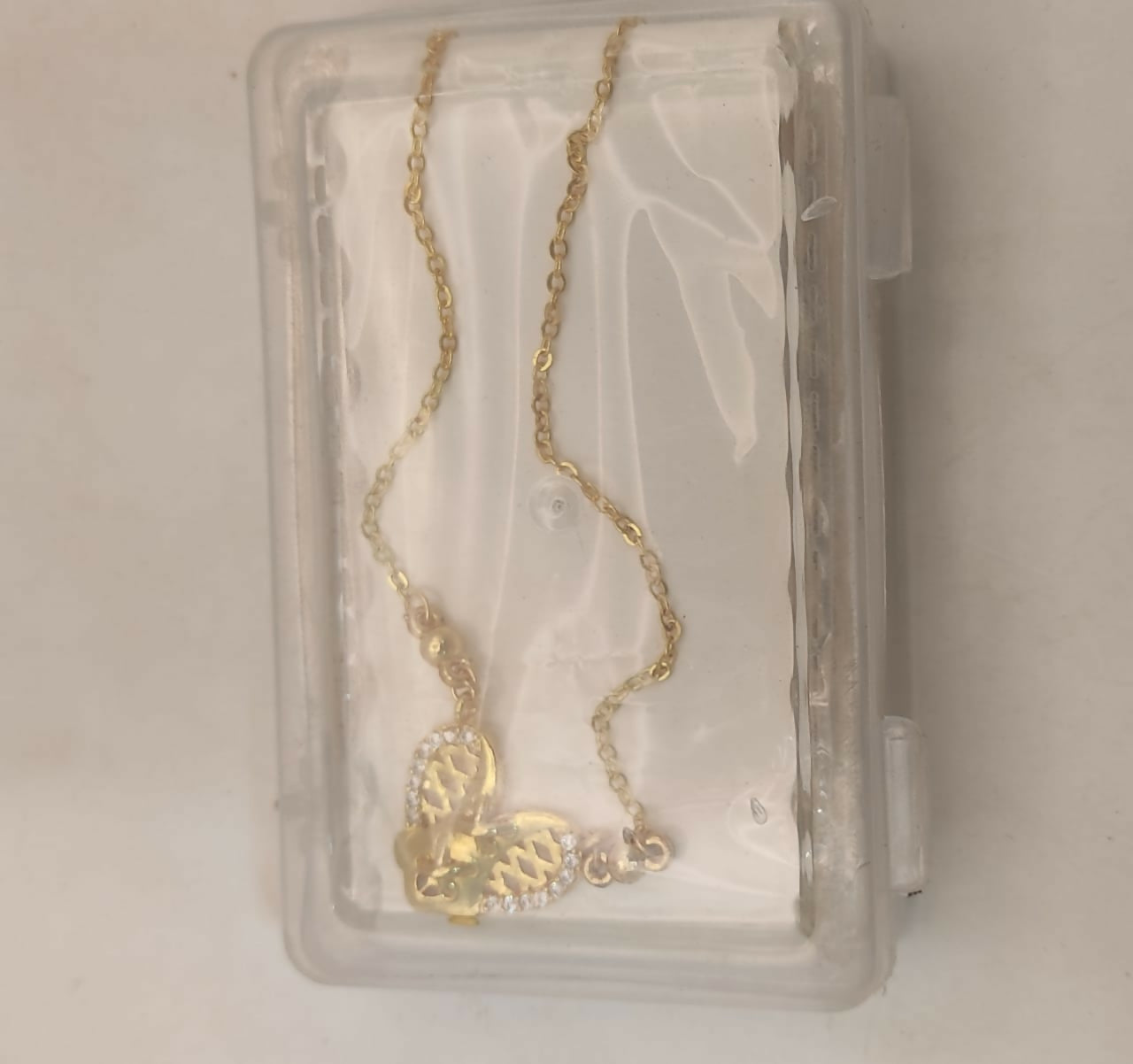 Side angle of gold pendant necklace featuring diamond accents
