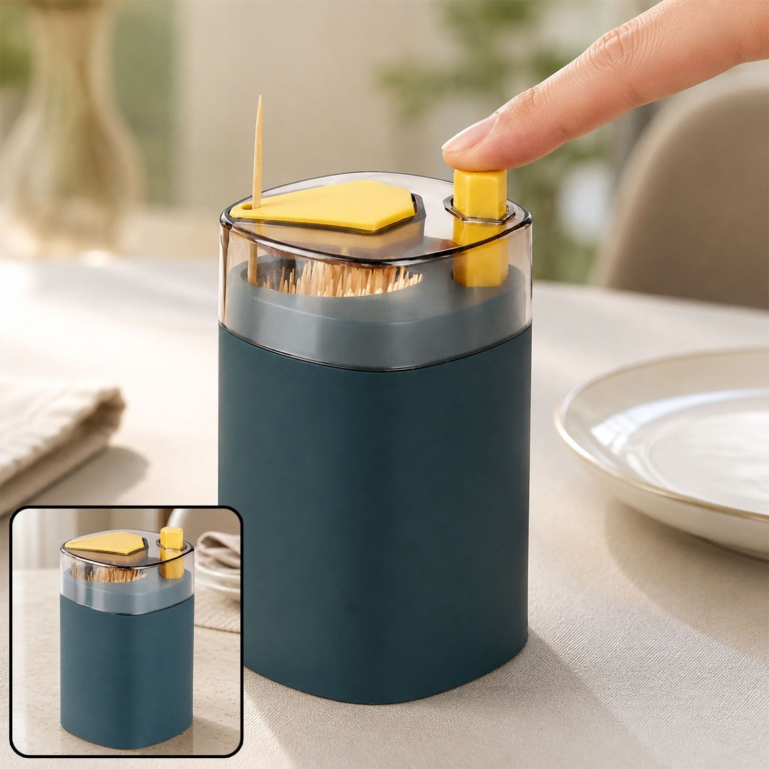 A hand presses the yellow button of a teal automatic toothpick dispenser, releasing a single toothpick. A smaller inset