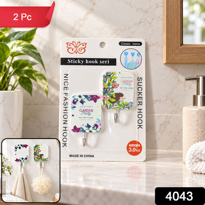 Packaged sticky hooks on a counter, with an inset showing a hand towel and loofah hanging from the hooks.