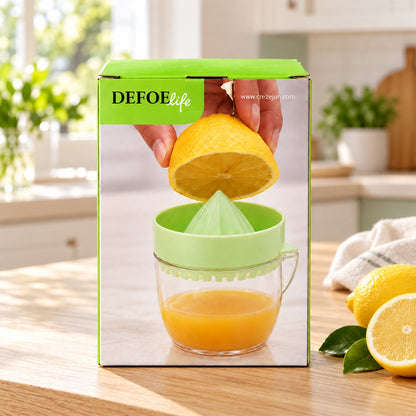 Green and clear manual citrus juicer on its box, with a lemon being squeezed into it.