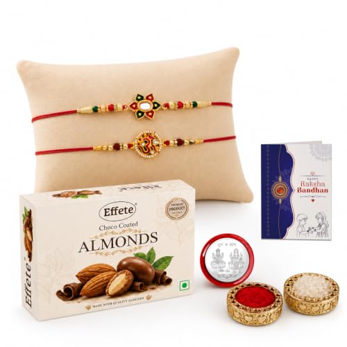 A gift set featuring two red and gold bracelets on a pillow, a box of chocolate almonds, a Raksha Bandhan card, and small