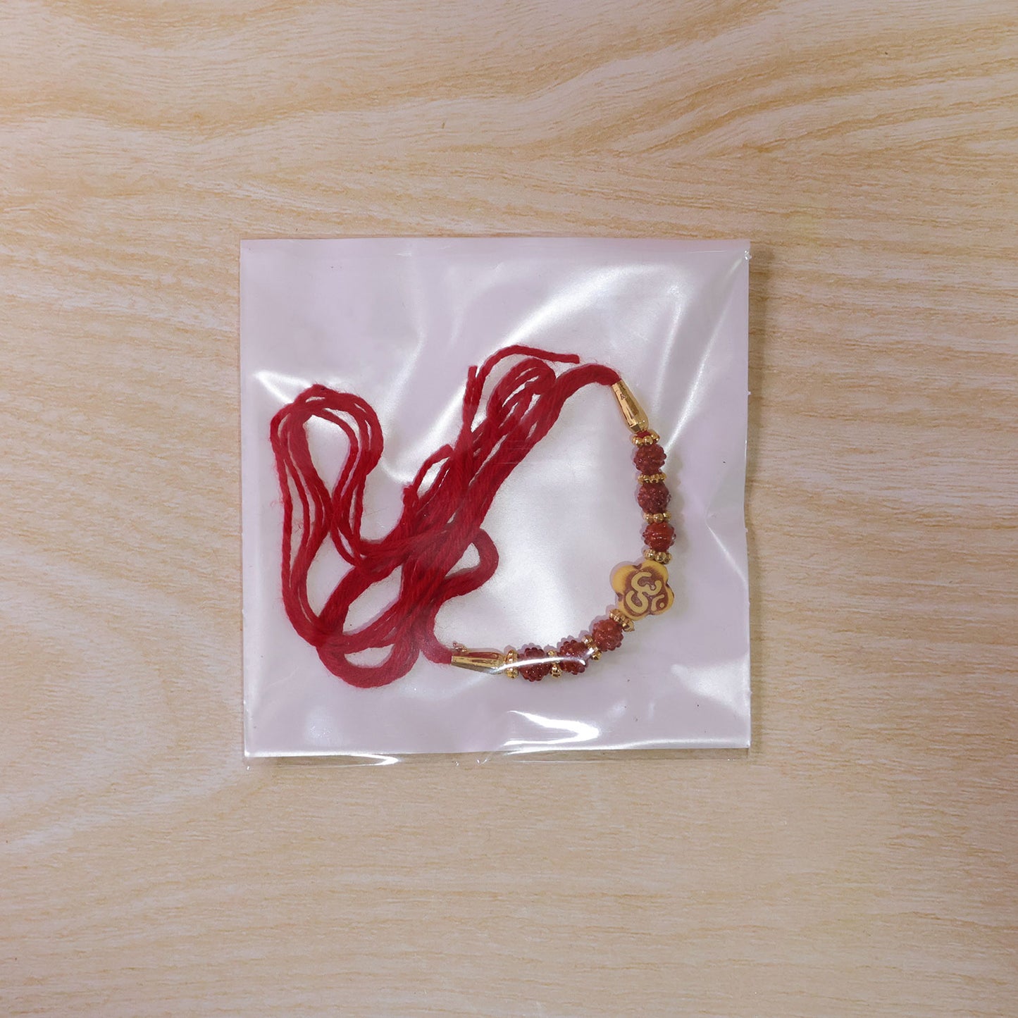 Om Bead Rakhi with Red Brown Accents and Spiritual Festive Brother Gift Styling Ideas