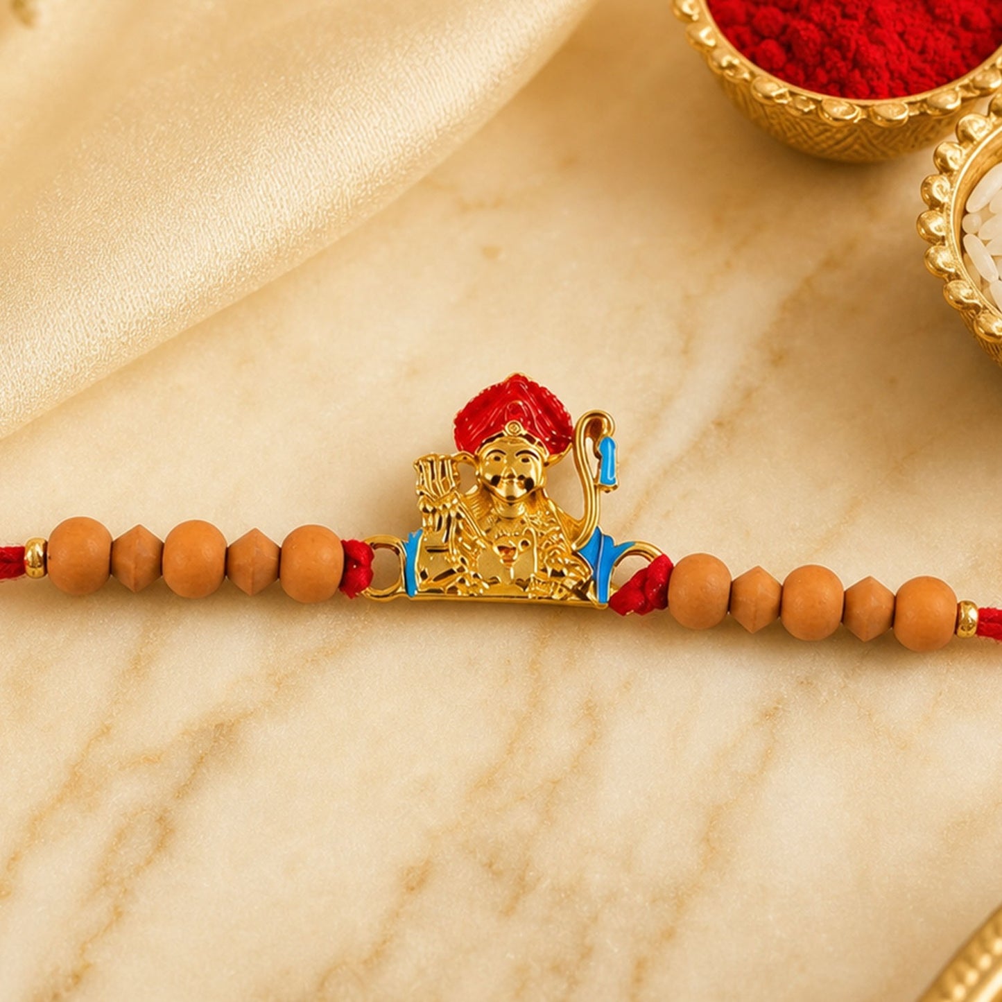 Auspicious golden deity Rakhi for brother with sandalwood beads for Raksha Bandhan.