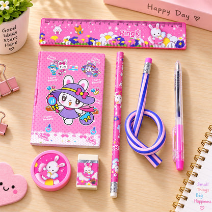 A pink rabbit-themed stationery set on a wooden table, including a ruler, notebook, two pencils, a pen, a sharpener, and an