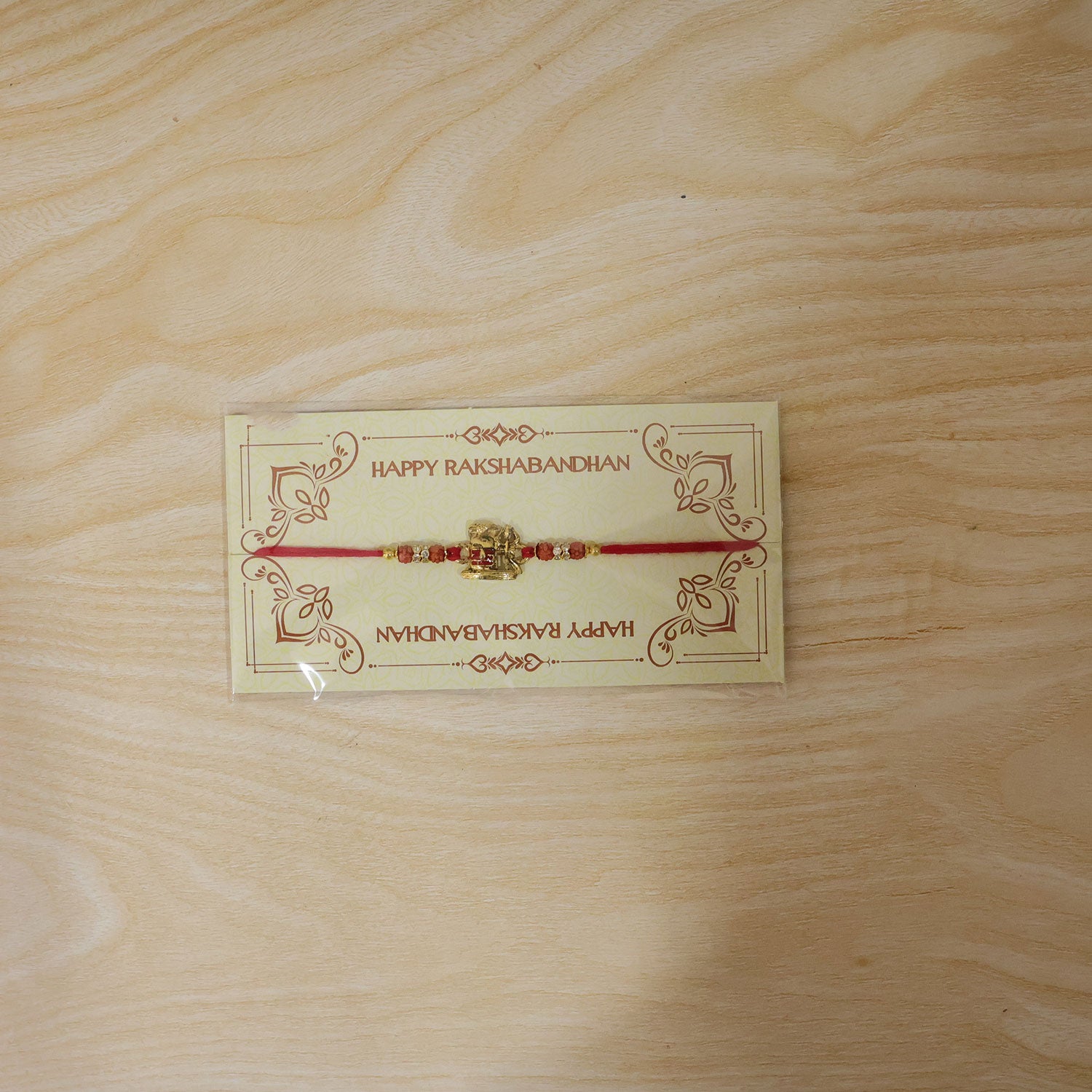 Shivling Trishul Devotional Rakhi with Golden Lord Shiva Centre and Orange Beads