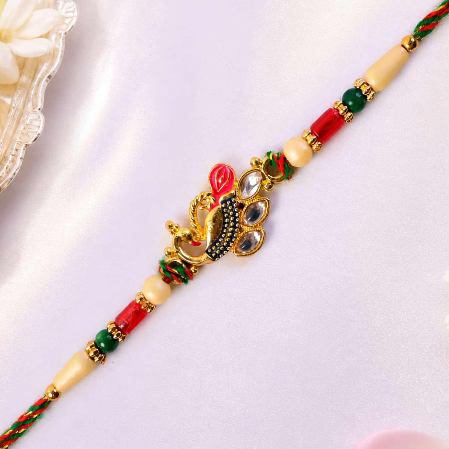 Diamond Shaped Kundan Pendant Rakhi with Peacock Feather Accent