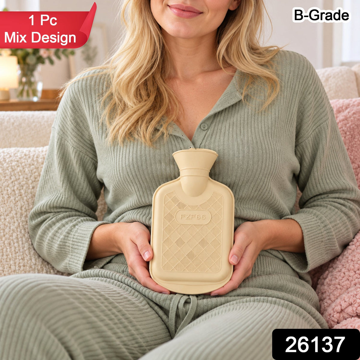 A smiling woman in light green loungewear holds a cream hot water bottle on her lap.